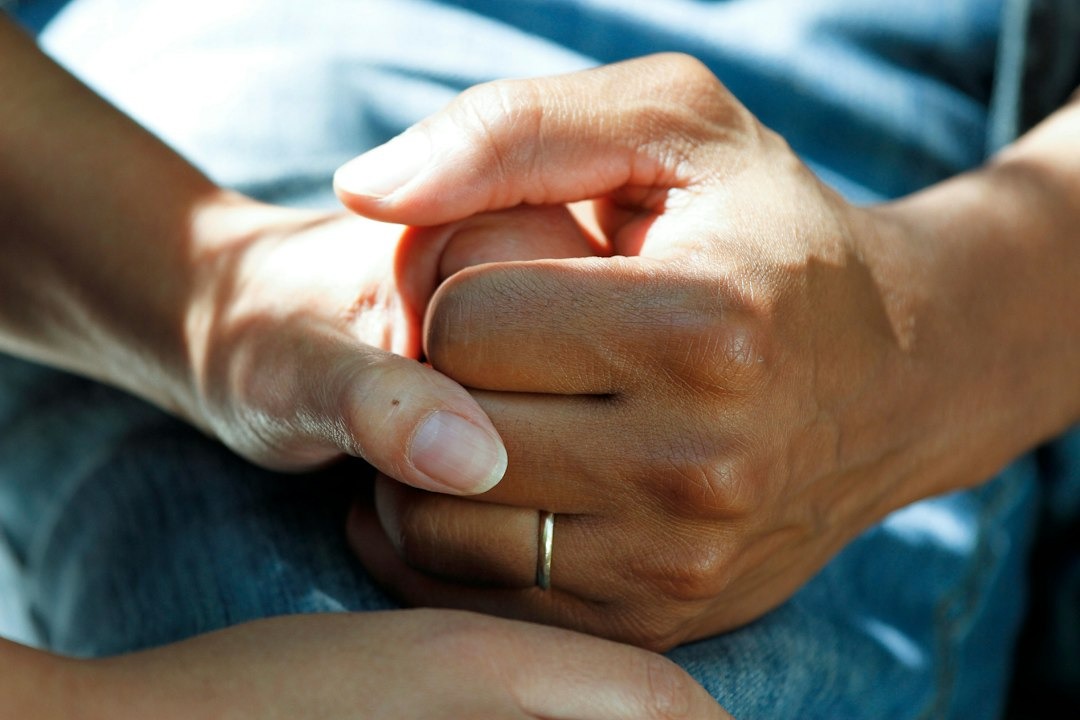 Two hands, one holding another, showing connection and support.